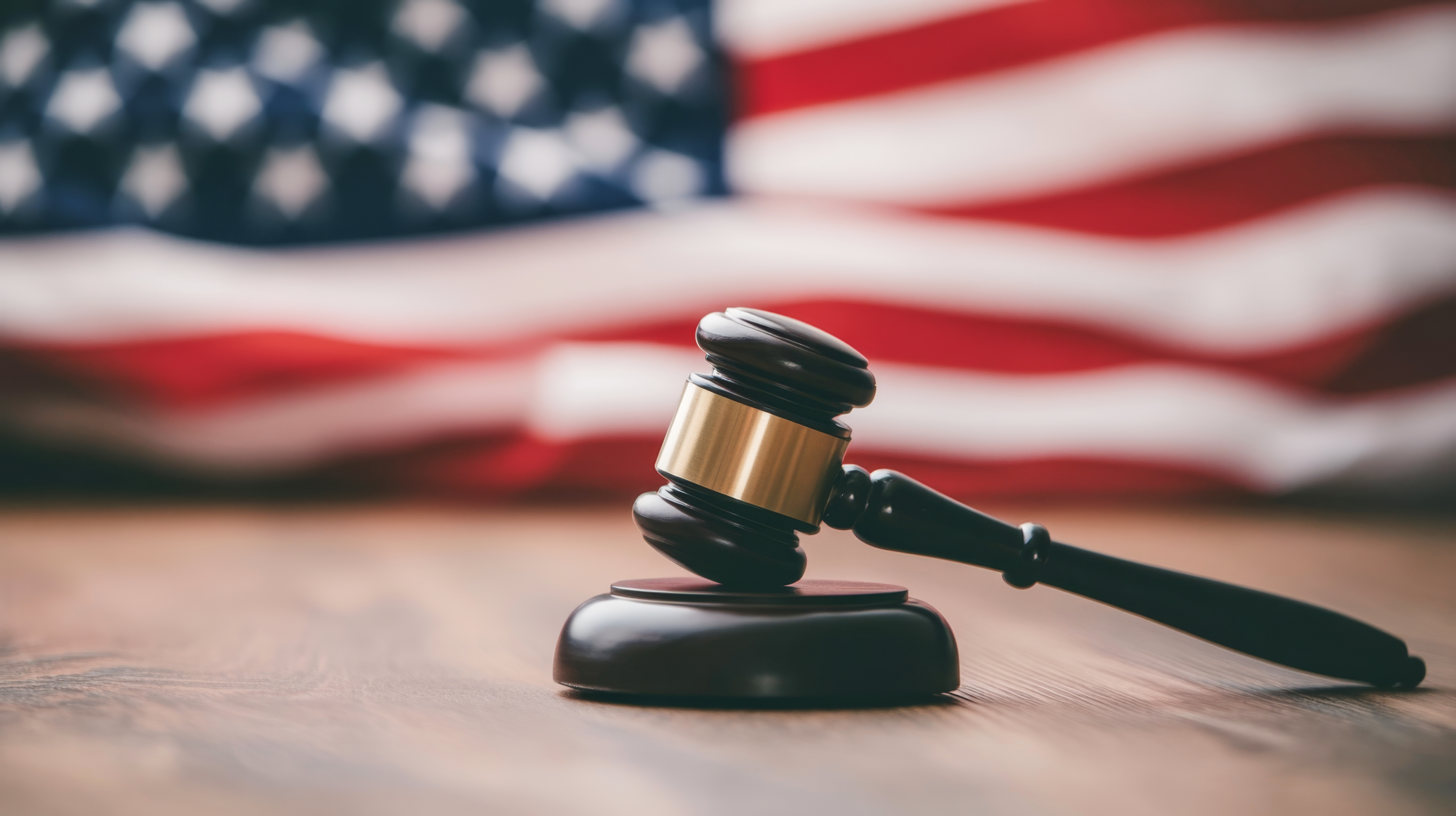 Rental counter handing keys in front of a glass wall of high-end vehicles